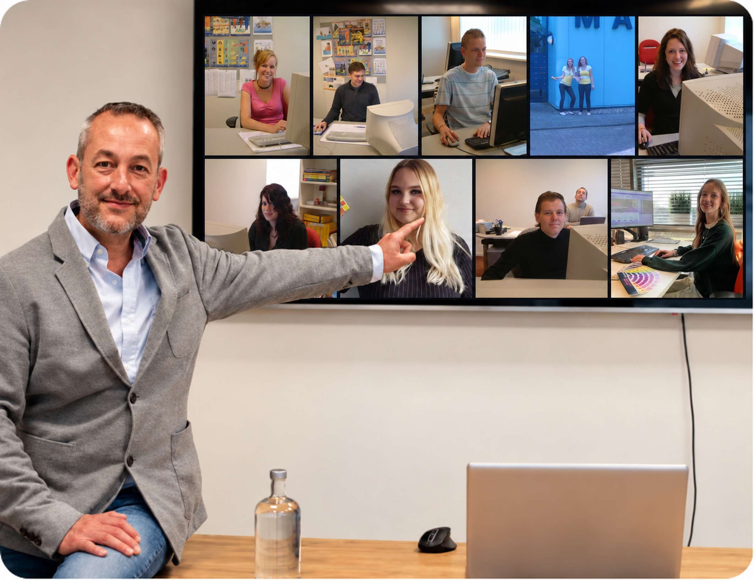 Serge wijst naar een scherm met foto's van stagiaires die hij begeleidde