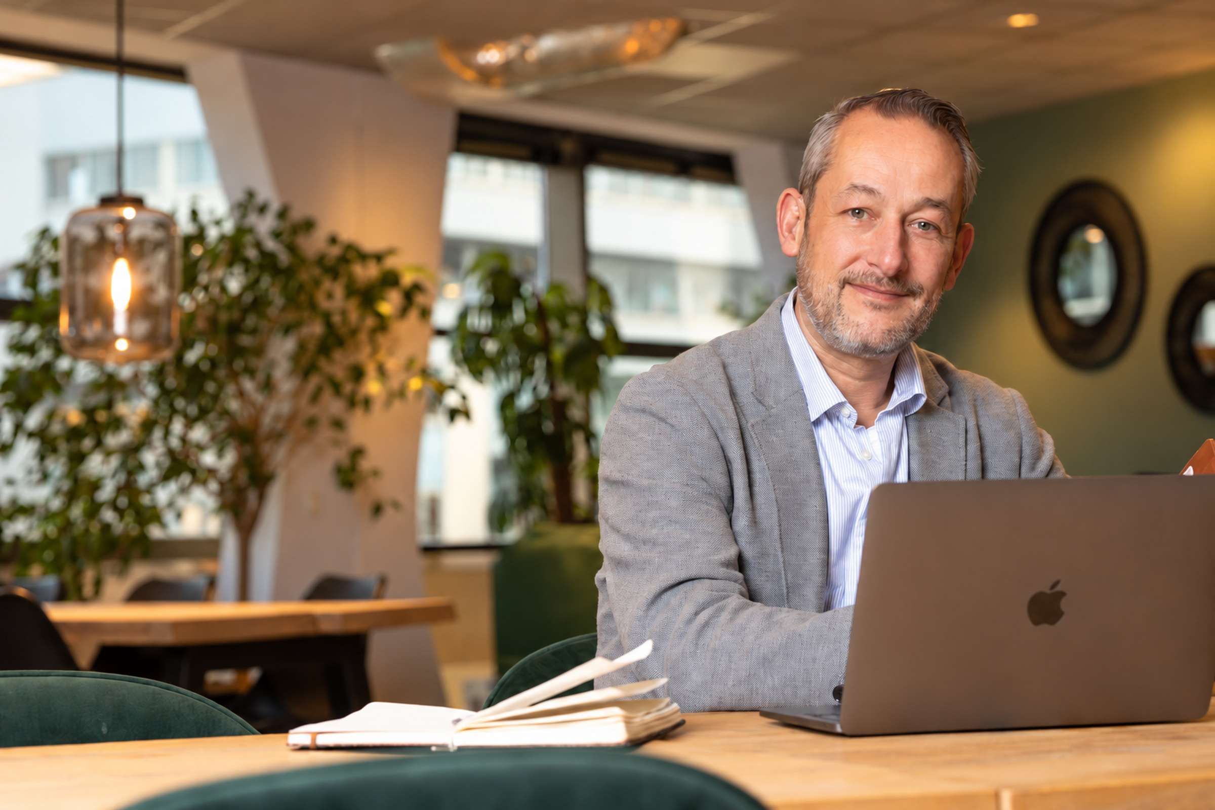 Serge van Rootz Media aan tafel met zijn laptop, kijkend in de camera